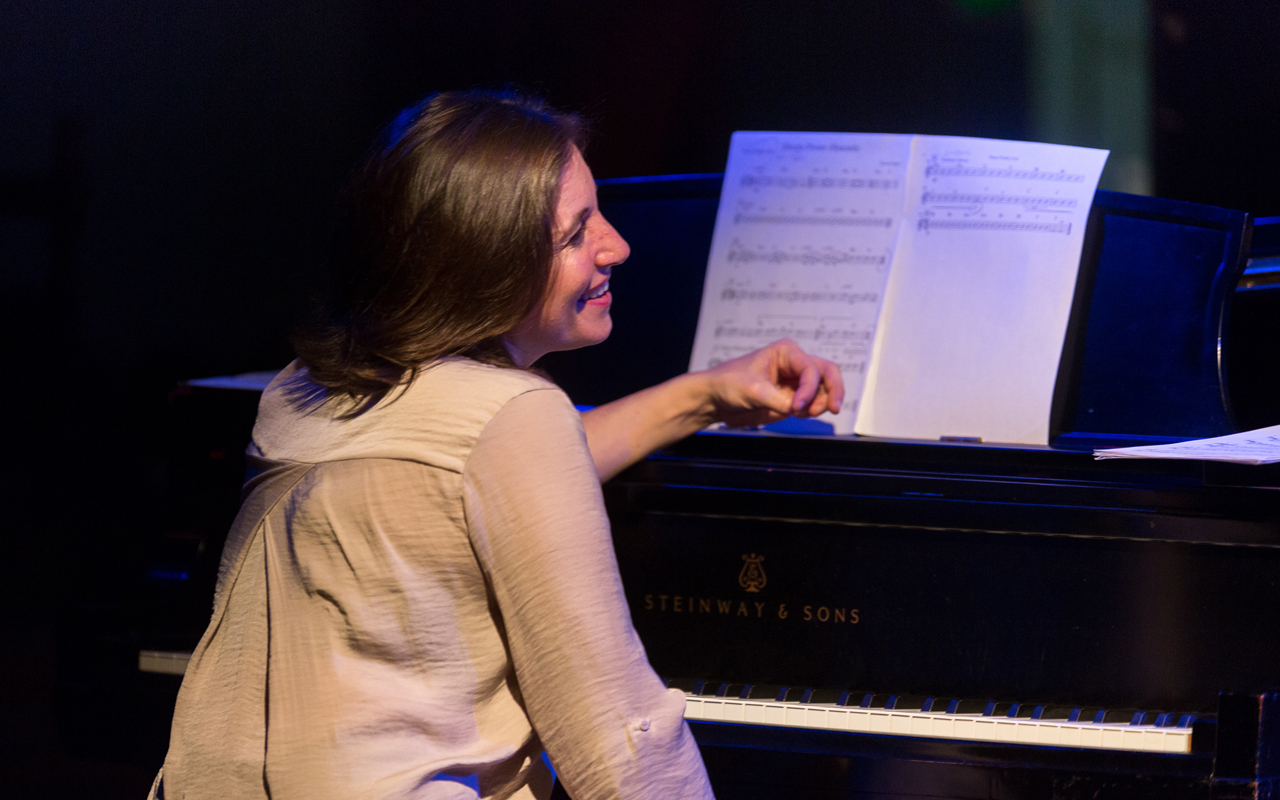 Marina Albero sitting at a piano smiling