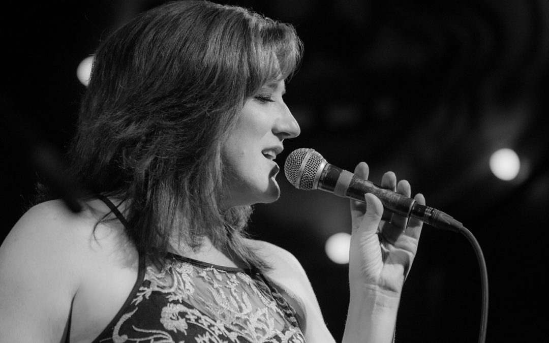 Nancy Erickson singing and holding microphone