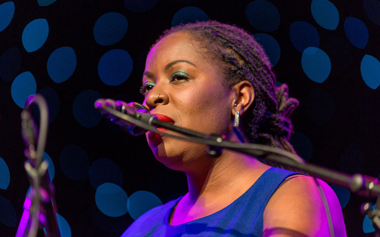 Johnaye Kendrick by Daniel Sheehan Johnaye Kendrick singing into a microphone