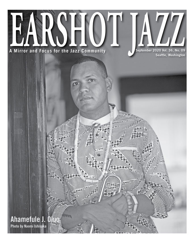 Cover of the 2020 August edition of the Earshot Jazz Magazine with black and white illustration of a record player, a take out box, ink pens, images of famous jazz musicians and the words "another world is possible"