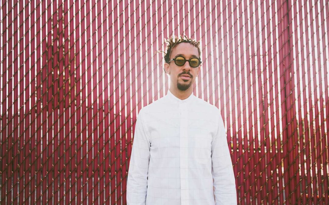 Gerald Clayton standing in front of a pink fence.