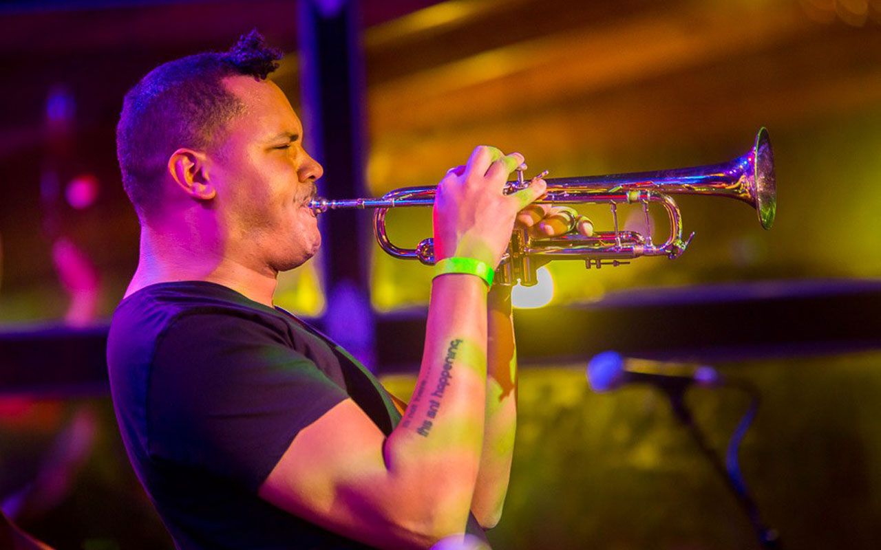 Ahamefule J. Oluo playing a trumpet on stage