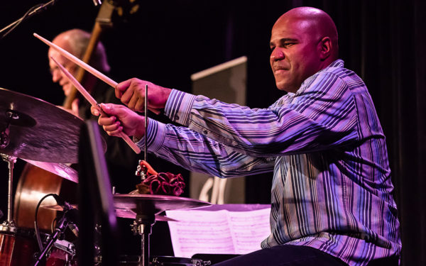 Photo of D'Vonne Lewis playing drums.