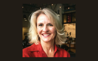 Arlene Fairfield wearing a red shirt, and smiling at the camera.