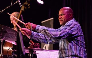 D'Vonne Lewis playing the drums in profile